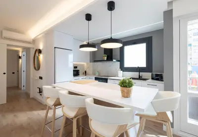 a kitchen with a white island and white chairs at Stay U-nique Apartments Villarroel II in Barcelona
