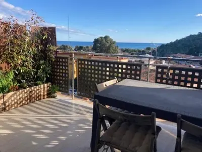 a patio with a table and chairs on a balcony at Apartamento con vistas al mar in Castelldefels
