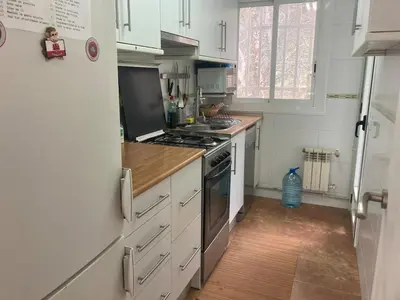 a kitchen with a stove and a white refrigerator at Apartamento con vistas al mar in Castelldefels