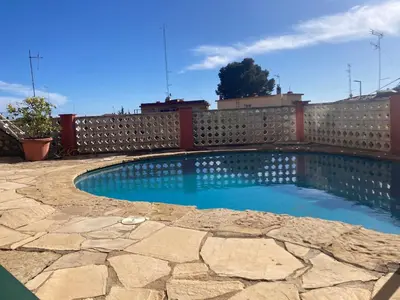 a swimming pool in front of a fence at Apartamento con vistas al mar in Castelldefels