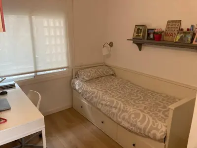 a small bed in a room with a window at Apartamento con vistas al mar in Castelldefels