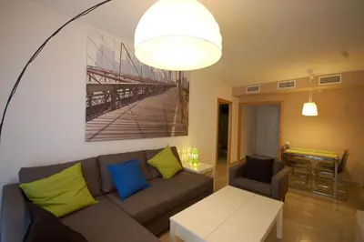 a living room with a couch and a table at Lets Holidays New Flat Beachfront In Castelldefels in Castelldefels