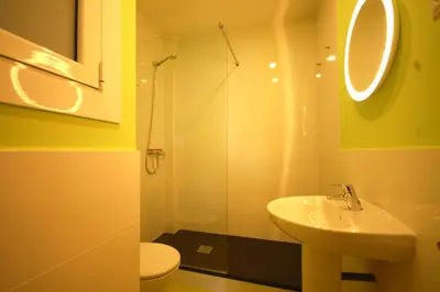 a bathroom with a sink and a glass shower at Lets Holidays New Flat Beachfront In Castelldefels in Castelldefels