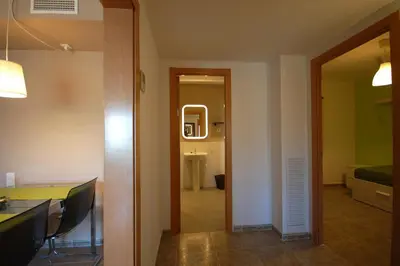a room with a hallway with a table and chairs at Lets Holidays New Flat Beachfront In Castelldefels in Castelldefels