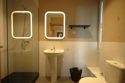 a bathroom with a sink and a toilet and mirrors at Lets Holidays New Flat Beachfront In Castelldefels in Castelldefels