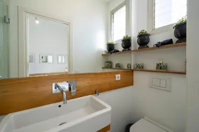a bathroom with a sink and a toilet and a mirror at Habitat Apartments Vila in Barcelona