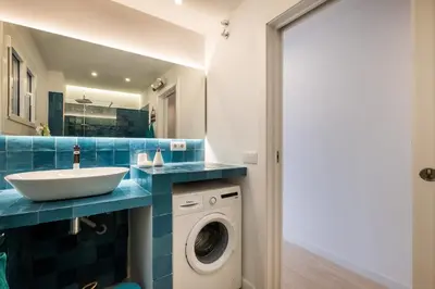 a bathroom with a sink and a washing machine at Apartamento artístico Vilanova in Vilanova i la Geltrú