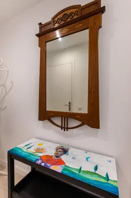 a mirror hanging on a wall next to a table at Apartamento artístico Vilanova in Vilanova i la Geltrú