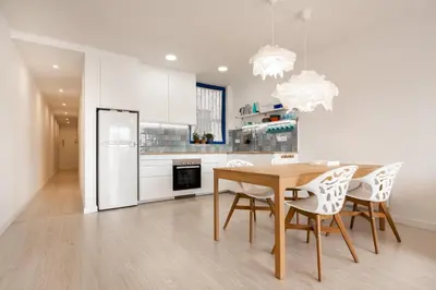 a kitchen with a table and chairs and a refrigerator at Apartamento artístico Vilanova in Vilanova i la Geltrú