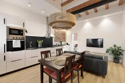 a kitchen and dining room with a table and a couch at Poble Sec Charming Apartment in Barcelona