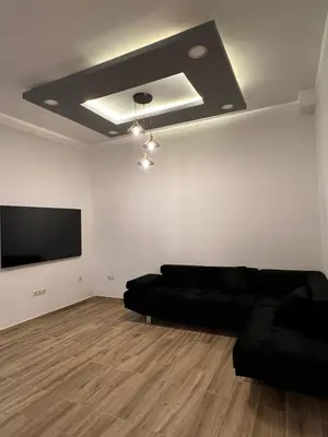 a living room with a black couch and a flat screen tv at Modern apartment Barcelona in Badalona