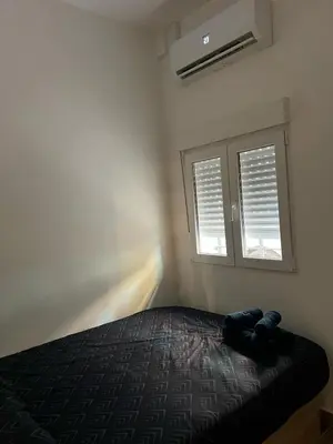 a bedroom with a bed and two windows at Modern apartment Barcelona in Badalona