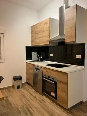 a kitchen with stainless steel appliances and wooden cabinets at Modern apartment Barcelona in Badalona