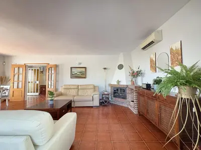 a living room with a couch and a fireplace at Charming Catalan Villa with Pool & Views in Cunit