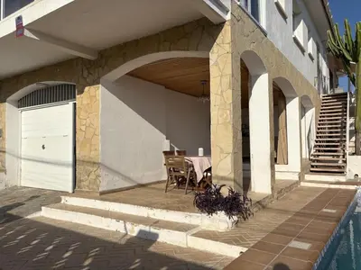 a house with a patio with a table and a door at Charming Catalan Villa with Pool & Views in Cunit
