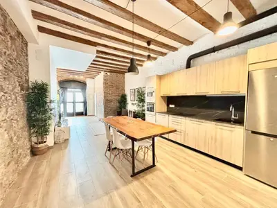 a kitchen with a wooden table in a room at Piso con dos habitaciones con camas dobles y terrazas en el Poblenou in Barcelona