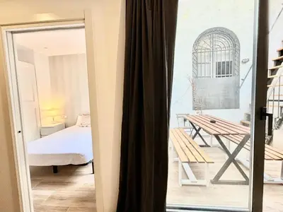 a door leading to a room with a bed and a table at Piso con dos habitaciones con camas dobles y terrazas en el Poblenou in Barcelona