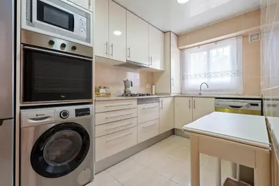 a kitchen with a washing machine and a microwave at Hauzify I Casa Ribera in Cunit