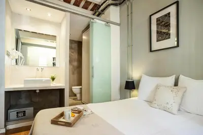 a bedroom with a white bed and a sink at Click&Flat Gothic apartments in Barcelona