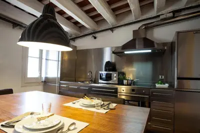 a large kitchen with a wooden table with plates on it at Click&Flat Gothic apartments in Barcelona