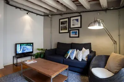 a living room with a blue couch and a tv at Click&Flat Gothic apartments in Barcelona