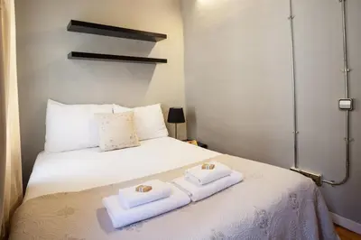 a white bed with two towels on top of it at Click&Flat Gothic apartments in Barcelona
