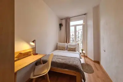 a bedroom with a bed and a desk and a window at 21ARA1085- Fabulous 4BR apartment in Ciutat Vella in Barcelona