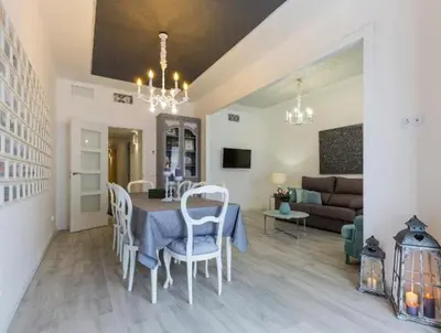 a dining room and living room with a table and chairs at Nice, Cozy, UP TO 6, FCB stadium, free parking in Barcelona