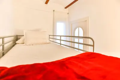a bedroom with a bed with a red blanket on it at Montroig Mar in Sitges