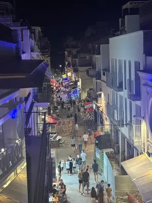 a group of people walking down a street at night at Montroig Mar in Sitges