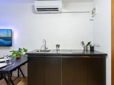 a kitchen with a sink and a counter with a table at Apartments near the airport in Cornellà de Llobregat
