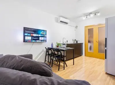 a living room with a couch and a table and a kitchen at Apartments near the airport in Cornellà de Llobregat