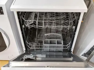 an open dishwasher with a dish rack in it at Apartments near the airport in Cornellà de Llobregat