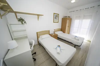 a small room with two beds and a window at HomeHolidaysRentals Olai - Costa Barcelona in Pineda de Mar