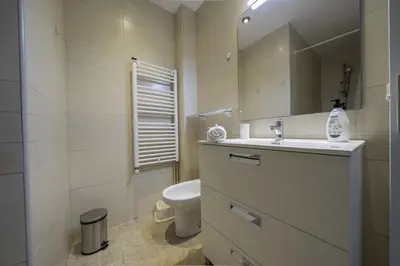 a bathroom with a sink and a toilet and a mirror at HomeHolidaysRentals Olai - Costa Barcelona in Pineda de Mar