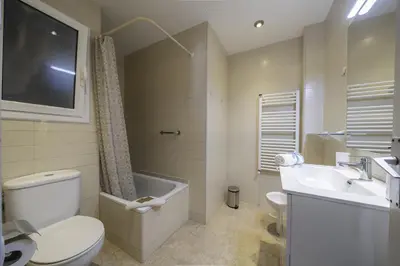 a bathroom with a toilet and a sink and a tv at HomeHolidaysRentals Olai - Costa Barcelona in Pineda de Mar