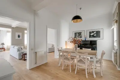 a white living room with a table and chairs at Rambla Catalunya Sky in Barcelona