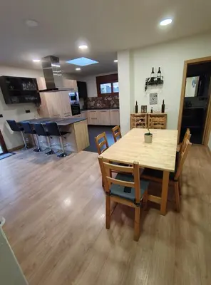 a kitchen and dining room with a wooden table and chairs at Estrella Relax in Vallirana