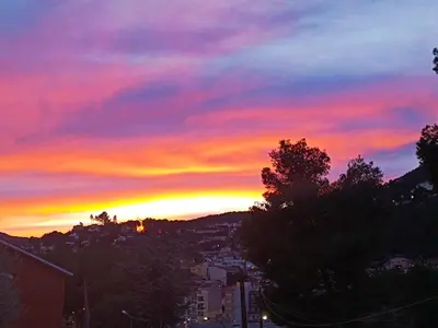 a sunset over a city with trees and buildings at Estrella Relax in Vallirana