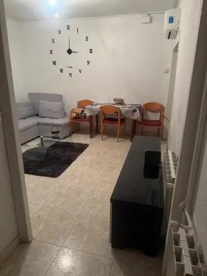 a living room with a couch and a clock on the wall at Dormir sleep Comidad 100 in Barcelona