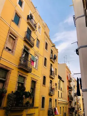 a tall yellow building with balconies on a street at Habitación privada junto al mar en la Barceloneta in Barcelona