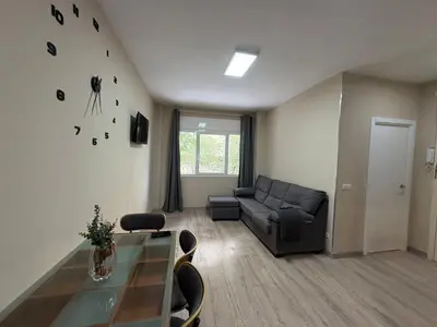 a living room with a couch and a glass table at FELIPE II Apartment in Barcelona