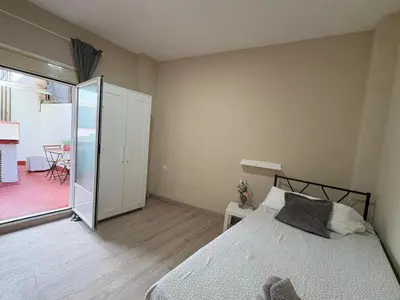 a bedroom with a bed and a sliding glass door at FELIPE II Apartment in Barcelona