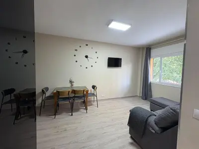 a living room with a table and chairs and a couch at FELIPE II Apartment in Barcelona