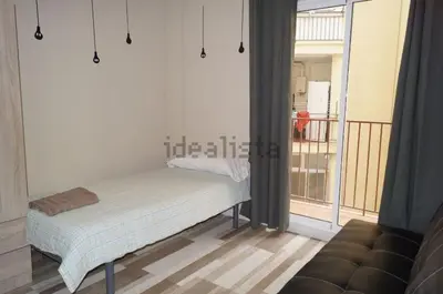 a bed in a room with a large window at FELIPE II Apartment in Barcelona