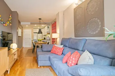 a living room with a blue couch with pillows at Click&Flat Charming Riera in Barcelona