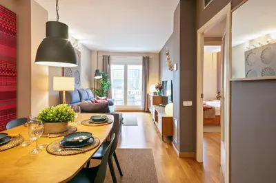 a dining room and living room with a table and chairs at Click&Flat Charming Riera in Barcelona