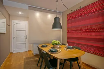 a dining room with a wooden table and a red wall at Click&Flat Charming Riera in Barcelona