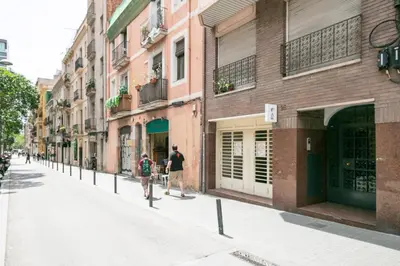 two people walking down a street next to buildings at Click&Flat Charming Riera in Barcelona