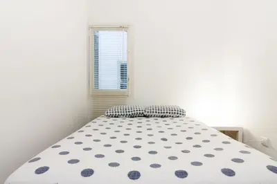 a white bedroom with a large bed with a window at Pubone AT Barberà del Valles in Barbera del Valles